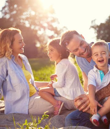 Parkta keyifli vakit geçiren, gülümseyen aile